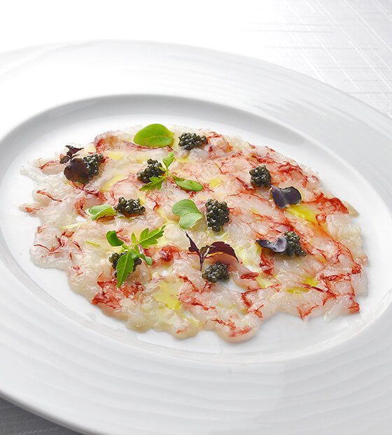 Un carpaccio de gambas aux baies roses et coriandre